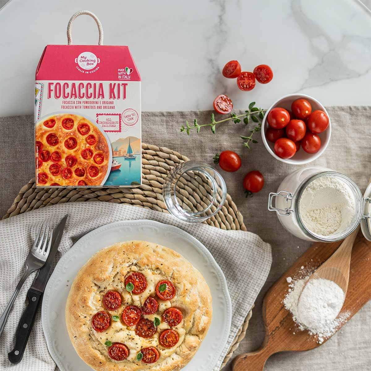 focaccia kit e piatto con focaccia fatta in casa con pomodorini e origano